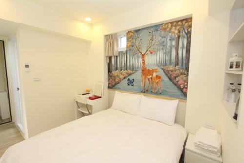 a bedroom with a white bed and a painting on the wall at Sea Keelung in Keelung