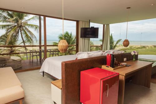 a living room with a bed and a table with a tv at Pousada Kiriri in Itarema