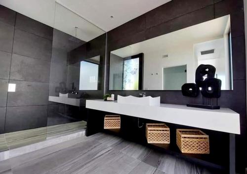 La salle de bains est pourvue d'un lavabo et d'un grand miroir. dans l'établissement D'VINO Valle De Guadalupe, à Ensenada