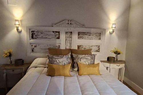 sypialnia z dużym białym łóżkiem z poduszkami w obiekcie Precioso Apartamento 2 Hab con Bañera Hidromasaje w mieście O Barco de Valdeorras