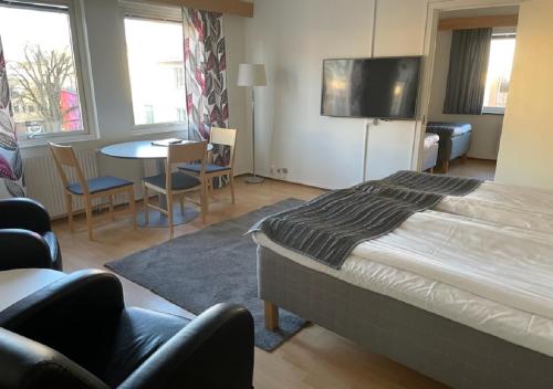 um quarto com uma cama, uma mesa e cadeiras em Linköpings Cityhotell och Vandrarhem em Linköping