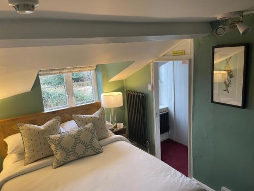 ein Schlafzimmer mit einem großen weißen Bett mit Kissen in der Unterkunft Myrtle Cottage B&B in Porlock