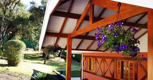 a house with flowers on the side of it at Pousada Casa dos Sonhos in Campos do Jordão