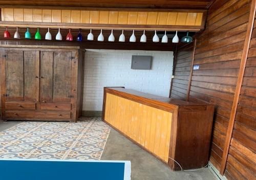 ペトロポリスにあるCasa acolhedora com lazer e espaço gourmetの大きな木製デスク、木製キャビネットが備わる客室です。
