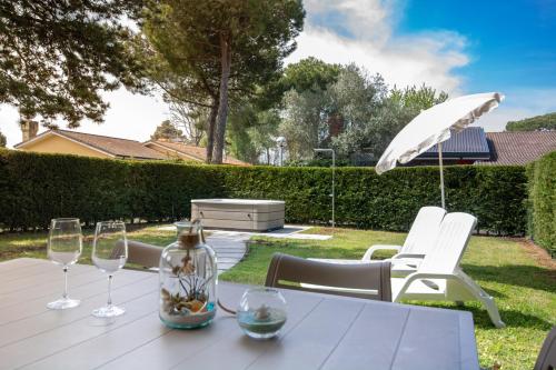 a table with wine glasses and an umbrella at Isola di Albarella in Isola Albarella
