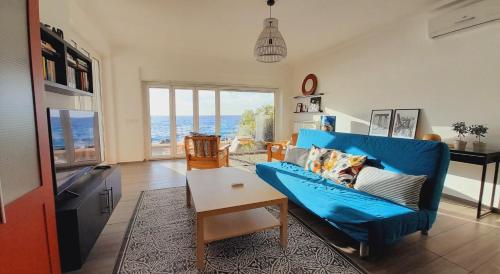 a living room with a blue couch and a table at Marina Holiday Home in Pizzo