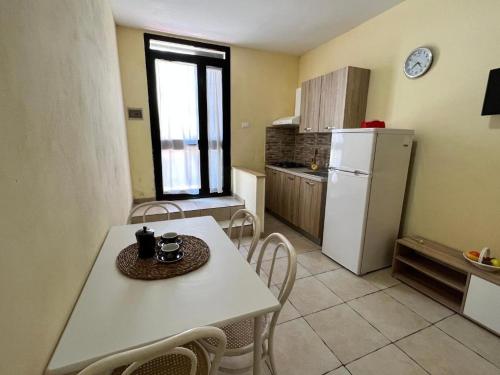 uma cozinha com uma mesa branca e um frigorífico branco em Casa Max - a 60 passi dal mare em San Foca