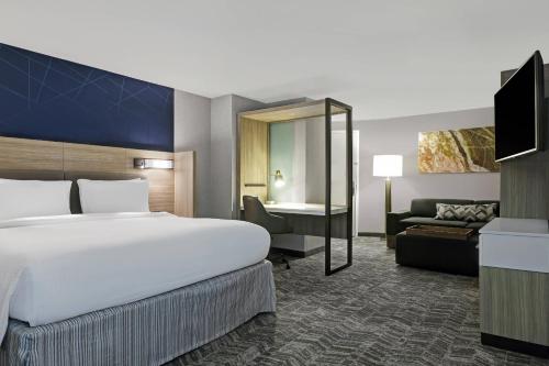 Pokój hotelowy z dużym łóżkiem i kanapą w obiekcie SpringHill Suites by Marriott Palm Desert w mieście Palm Desert