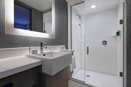 a white bathroom with a sink and a shower at SpringHill Suites by Marriott Palm Desert in Palm Desert
