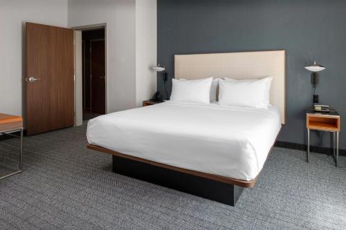 a bedroom with a large bed with white sheets and pillows at Courtyard by Marriott Memphis East Galleria in Memphis