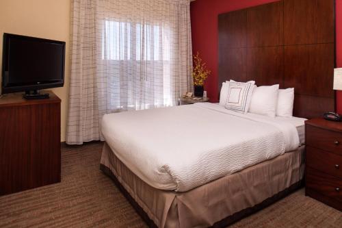 - une chambre avec un grand lit et une télévision à écran plat dans l'établissement Residence Inn by Marriott Albuquerque Airport, à Albuquerque