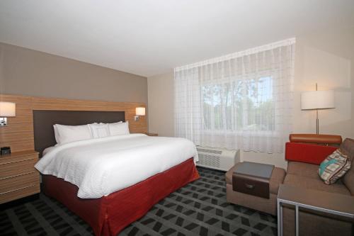 a hotel room with a large bed and a couch at TownePlace Suites by Marriott Charleston-North Charleston in Charleston