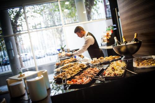 a man preparing food at a buffet line with food at Hotel degli Arcimboldi in Milan