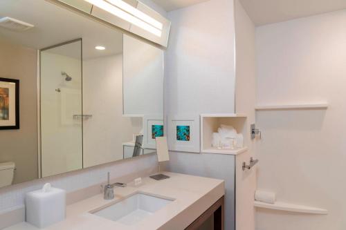 Baño blanco con lavabo y espejo en Courtyard by Marriott Cleveland Elyria en Elyria