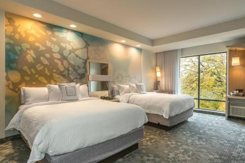 a bedroom with two beds and a large window at Courtyard by Marriott West Springfield in West Springfield