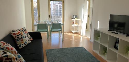 a living room with a black couch and a television at Free parking & 5min walk to Subway in Lisbon