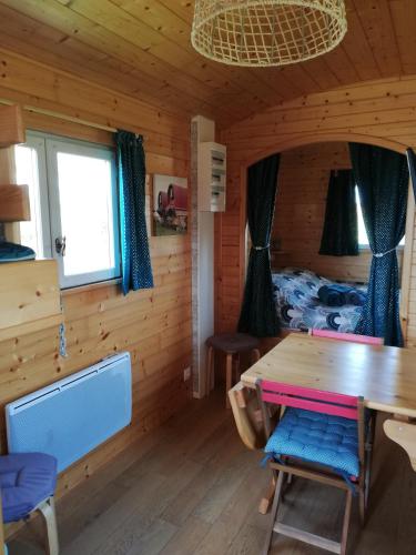 - une salle à manger avec une table dans une cabane en rondins dans l'établissement Roulot'So Zen, à Beslon
