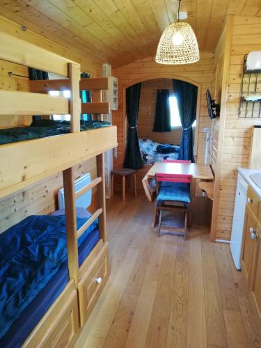 - une chambre avec des lits superposés et une table dans une cabine dans l'établissement Roulot'So Zen, à Beslon
