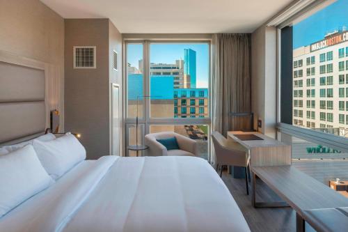 una camera con un grande letto e una grande finestra di AC Hotel by Marriott Boston Downtown a Boston