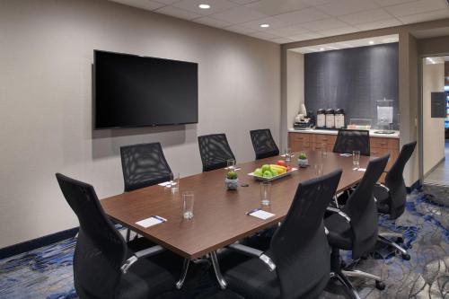 a conference room with a table and chairs and a screen at Fairfield Inn & Suites by Marriott Chicago O'Hare in Des Plaines
