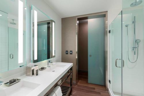 a bathroom with two sinks and a glass shower at AC Hotel by Marriott Boston Downtown in Boston