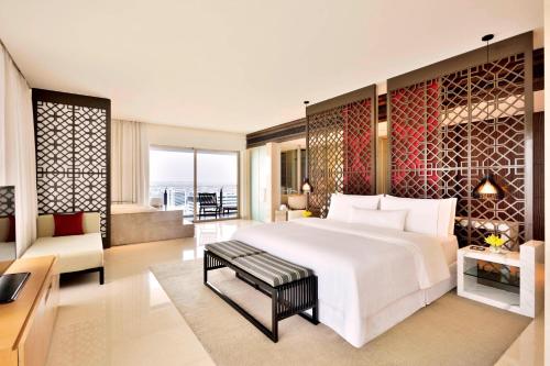 a bedroom with a large bed and a living room at The Westin Hyderabad Mindspace in Hyderabad