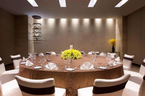 a large round table in a room with white chairs at The Westin Hyderabad Mindspace in Hyderabad