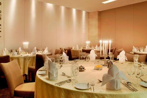 a dining room with tables and chairs with candles at The Westin Hyderabad Mindspace in Hyderabad