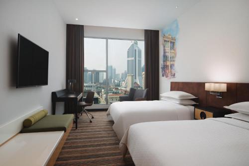 a hotel room with two beds and a window at Four Points by Sheraton Kuala Lumpur, Chinatown in Kuala Lumpur