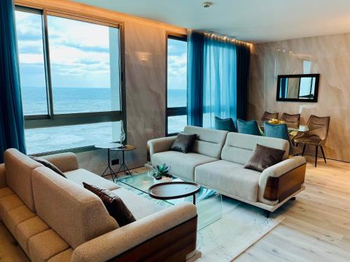 - un salon avec deux canapés et une vue sur l'océan dans l'établissement Carmel Holiday Apartments, à Netanya