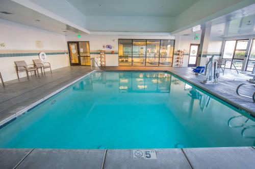 a large swimming pool with blue water in a building at Courtyard by Marriott Merced in Merced