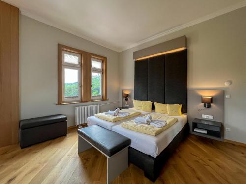 a bedroom with a large bed with a black headboard at Haus Hainstein in Eisenach