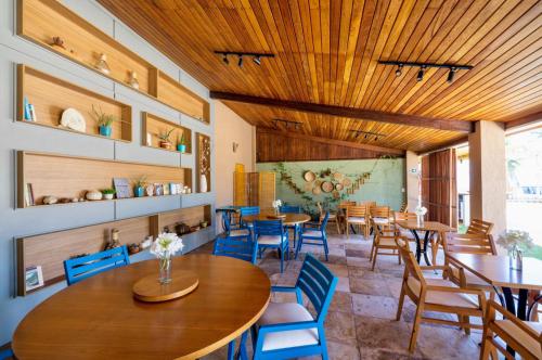 a restaurant with wooden ceilings and tables and chairs at Pousada Kiriri in Itarema