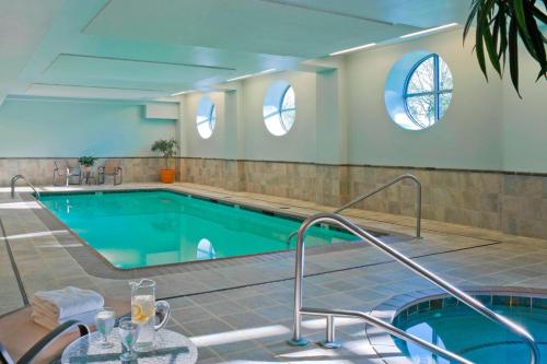 a large swimming pool with two windows in a building at Courtyard Burlington Harbor in Burlington