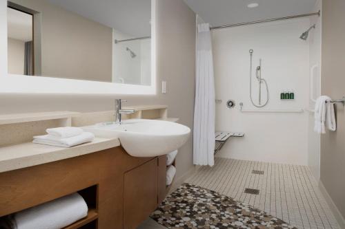 Baño blanco con lavabo y espejo en SpringHill Suites by Marriott Huntsville West/Research Park, en Huntsville