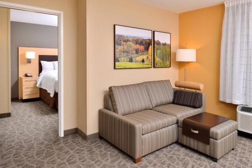 sala de estar con sofá y cama en TownePlace Suites by Marriott Detroit Commerce en Walled Lake