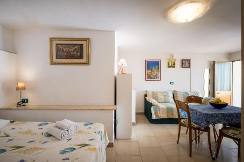 a living room with a table and a couch at Monolocale - Rosa sea view in villa in Santa Cesarea Terme