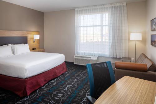a hotel room with a bed and a table at TownePlace Suites Midland South/I-20 in Midland