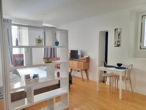 uma sala de estar com uma prateleira de livros brancos e uma mesa em Alfama Apartments Services em Lisboa