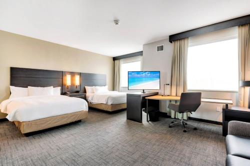 um quarto de hotel com duas camas e uma secretária e uma televisão em Residence Inn by Marriott Corpus Christi Downtown em Corpus Christi
