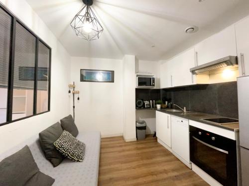 ein Wohnzimmer mit einem Sofa und einer Küche in der Unterkunft Appart 2 chambres gare St Charles in Marseille