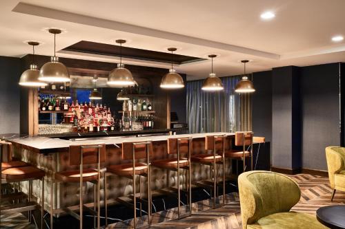 a bar in a restaurant with chairs and lights at AC Hotel by Marriott Nashville Brentwood in Brentwood