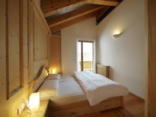 ein Schlafzimmer mit einem Bett in einem Zimmer mit einem Fenster in der Unterkunft Appartamenti Home Service in Arabba