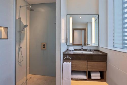 Residence Inn by Marriott Al Jaddaf في دبي: حمام مع حوض ومرآة
