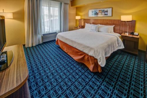 ラッセルビルにあるFairfield by Marriott Russellvilleのベッドとテレビが備わるホテルルームです。