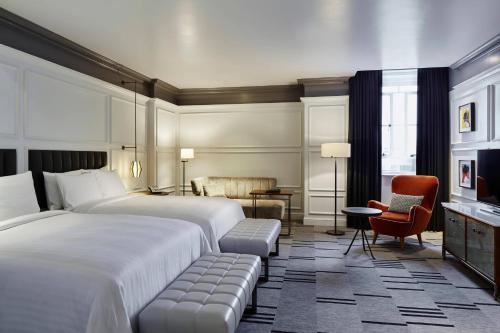 a hotel room with two beds and a couch at London Marriott Hotel County Hall in London