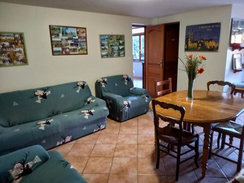 un salon avec un canapé, une table et des chaises dans l'établissement la ferme des tertres, à La Chapelle-près-Sées
