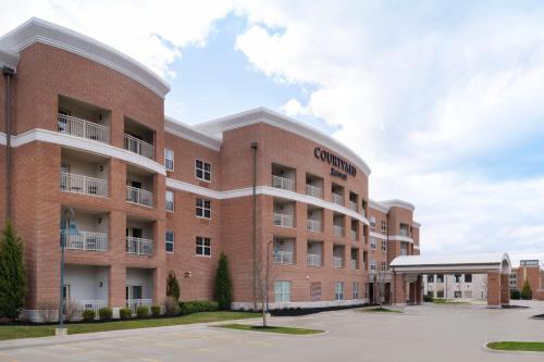 New AlbanyにあるCourtyard by Marriott Columbus New Albanyの駐車場のある大きなレンガ造りの建物