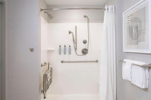 a white bathroom with a shower and a toilet at Courtyard by Marriott Columbus New Albany in New Albany