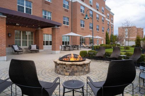 New AlbanyにあるCourtyard by Marriott Columbus New Albanyのパティオ(椅子付)、建物の前のファイヤーピット